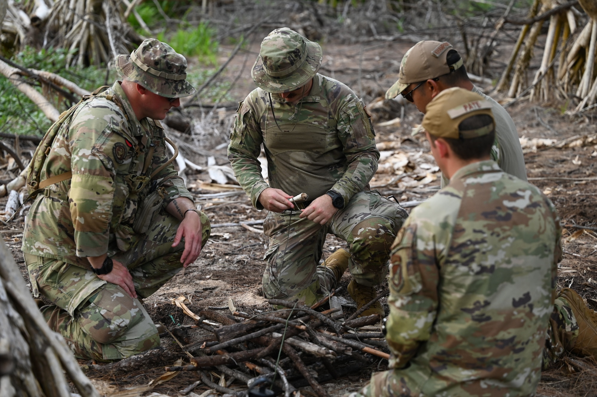 736th Security Forces Squadron Airmen build a fire pit during a Jungle Training Course on Andersen Air Force Base, Guam, July 25, 2024. In the latter weeks of July the 736th SFS participated in a Jungle Training Course aimed to enhance ground force capabilities in a jungle environment. They learned different survival skills such as water confidence, water purification, trap making, evasion tactics and other skills useful in jungle warfare. (U.S. Air Force photo by Airman 1st Class Adasha Williams)