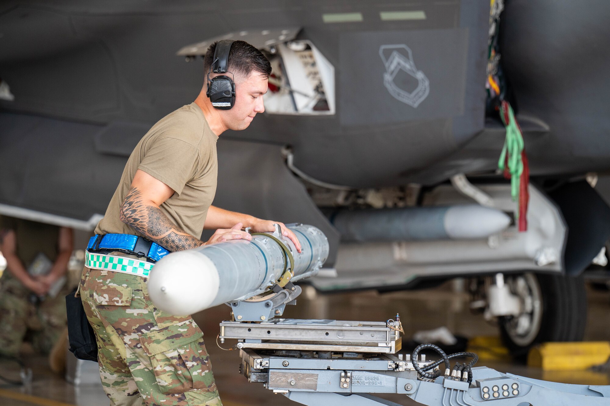 U.S. Air Force Staff Sgt. Brandon Castillo, 308th Aircraft Maintenance Unit maintainer, guides an AIM-120 AMRAAM missile during the 56th Maintenance Group 2nd quarter weapons load competition, July 12, 2024, at Luke Air Force Base, Arizona.