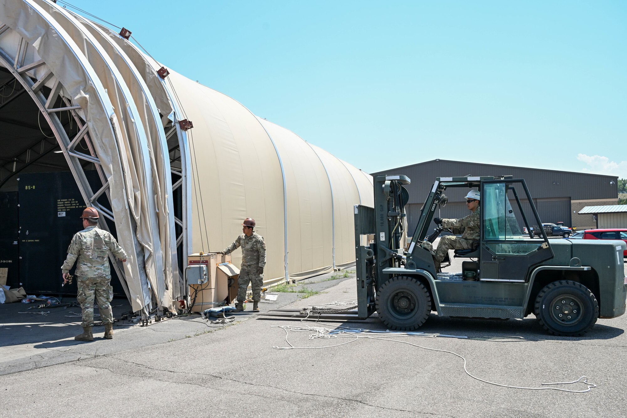 Airmen from the 635th Materiel Maintenance Squadron, based at Holloman Air Force Base, New Mexico, complete repairs on a clamshell tension fabric shelter system for 309th Aircraft Maintenance Group at Hill Air Force Base, Utah. The shelter stores critical aircraft parts and is used for “pack-and-crate” operations, where aircraft are prepared for ground or air transportation. (U.S. Air Force photo by Cynthia Griggs)