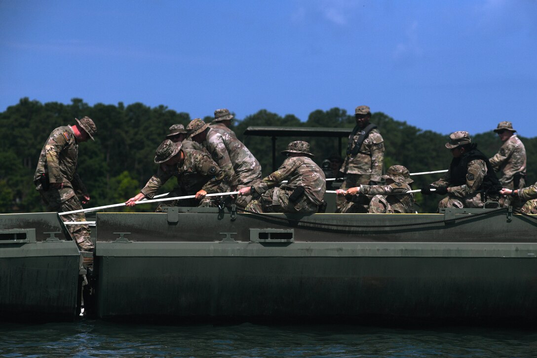 Soldiers with the 125th Multi-role Bridge Company, South Carolina Army National Guard, connect two Improved Ribbon Bridge sections during a training mission at Clarks Hill Training Site, S.C., July 17, 2024.