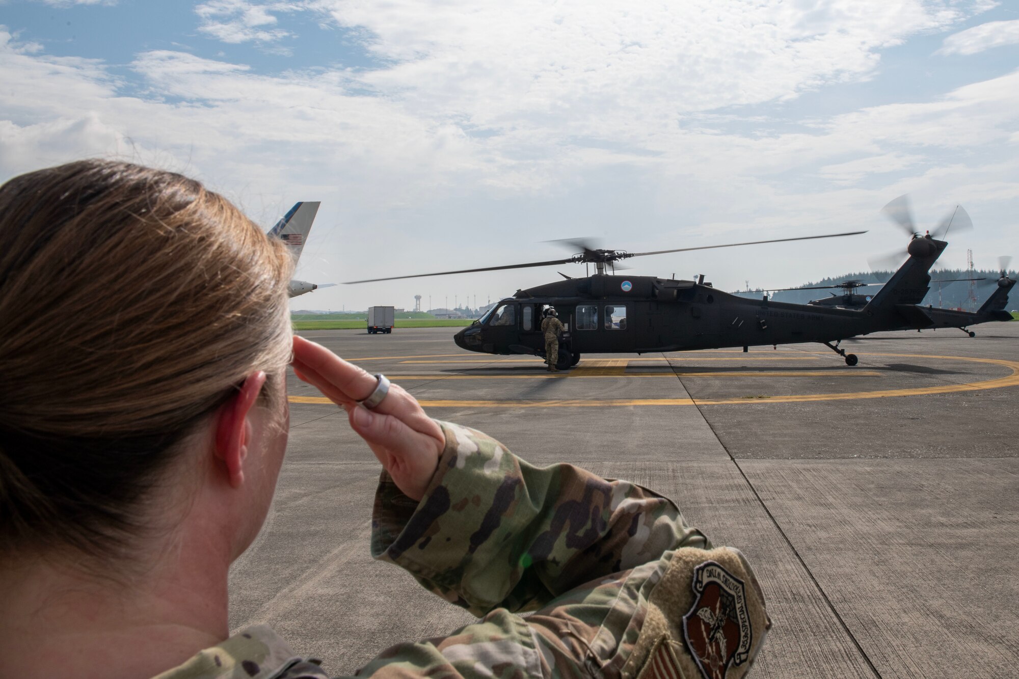 U.S. Air Force member salutes the Chairman of the Joint Chiefs of Staff as he arrives by helicopter.