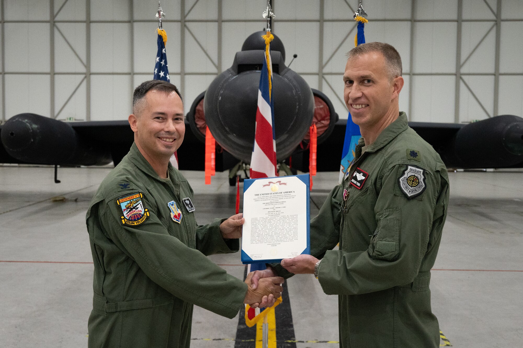 U.S. Air Force Col. Charles G. Cameron, left, 9th Operations Group commander, presents a meritorious service medal to Lt. Col. Jonathan D. Young, right, 99th Expeditionary Reconnaissance Squadron outgoing commander during a change of command ceremony.