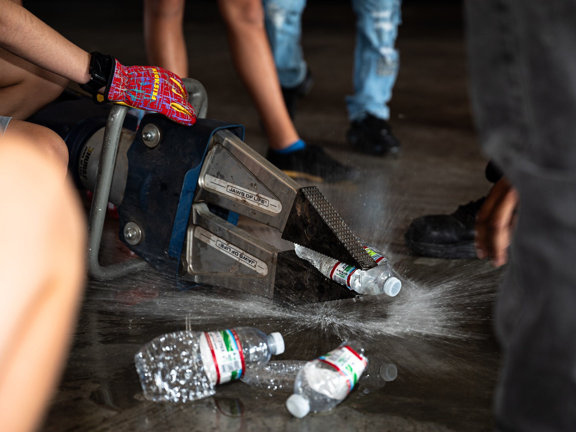 Children take turns operating a hydraulic rescue tool to crush water bottles during Junior Firefighter Camp at Dyess Air Force Base, Texas, July 16, 2024. Dyess firefighters demonstrated the power of the life-saving tools to the camp participants. (U.S. Air Force photo by Airman 1st Class Jade M. Caldwell)