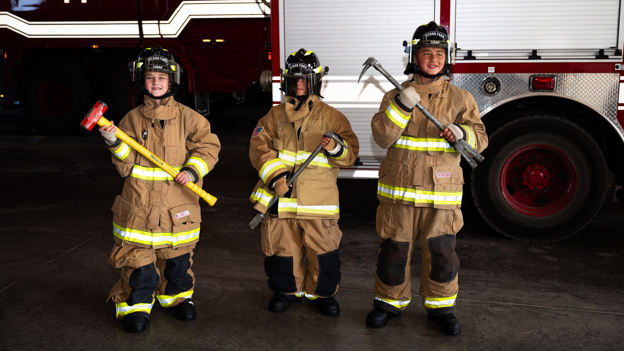 Children pose for a group photo during Junior Firefighter Camp at Dyess Air Force Base, Texas, July 16, 2024. Camp participants put on firefighter gear and competed to see who could put on all the gear in the shortest amount of time. (U.S. Air Force photo by Airman 1 st Class Jade M. Caldwell)