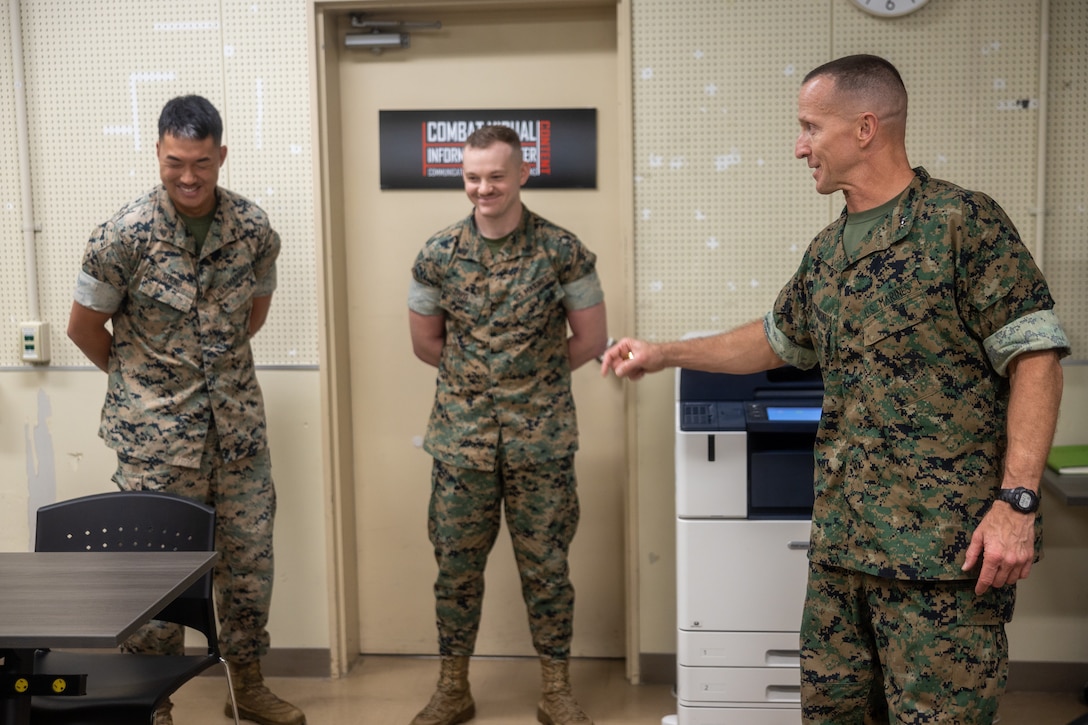 From left, U.S. Marine Corps Cpl. Thomas Sheng, a combat photographer, and Cpl. Jesse Davis, a combat graphic specialist, both with Communication Strategy and Operations, Headquarters and Support Battalion, Marine Corps Installations Pacific, are presented with challenge coins by Maj. Gen. Stephen Liszewski, commanding general of MCIPAC, for top placements in the Marine Corps Visual Information and Excellence Awards competition on Camp Foster, Okinawa, Japan, June 3, 2024. Sheng is this year’s Marine Corps Writer of the Year, the DoD Thomas Jefferson Writer of the Year. Davis is the first place graphic designer for Identity and Design. Lisewski visited MCIPAC Marines to present awards and challenge coins in recognition of their work. Liszewski is a native of Maryland, Sheng is a native of Texas, and Davis is a native of Florida. (U.S. Marine Corps Photo by Sgt. Maximiliano Rosas)