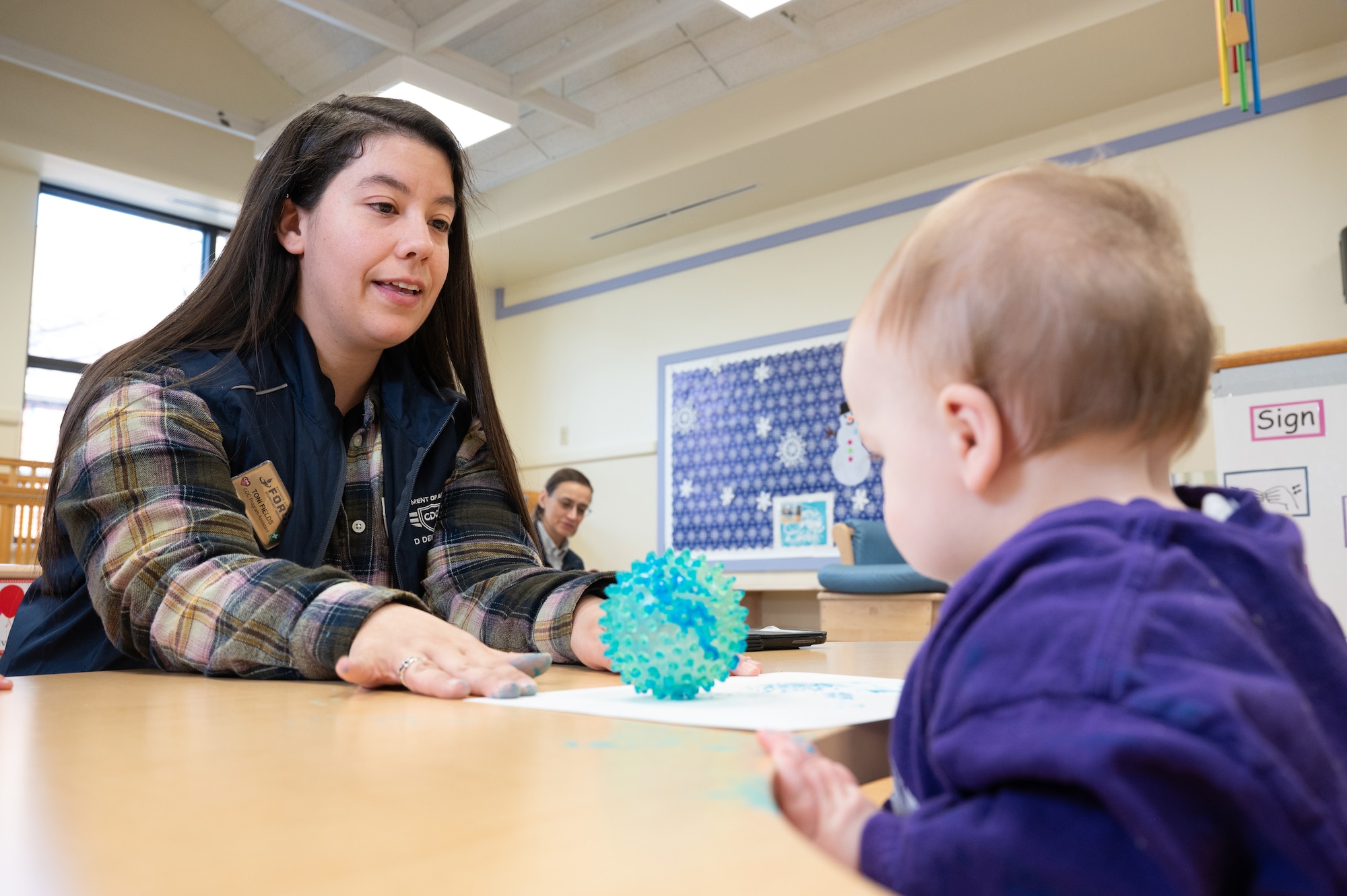 Image of woman interacting with child.