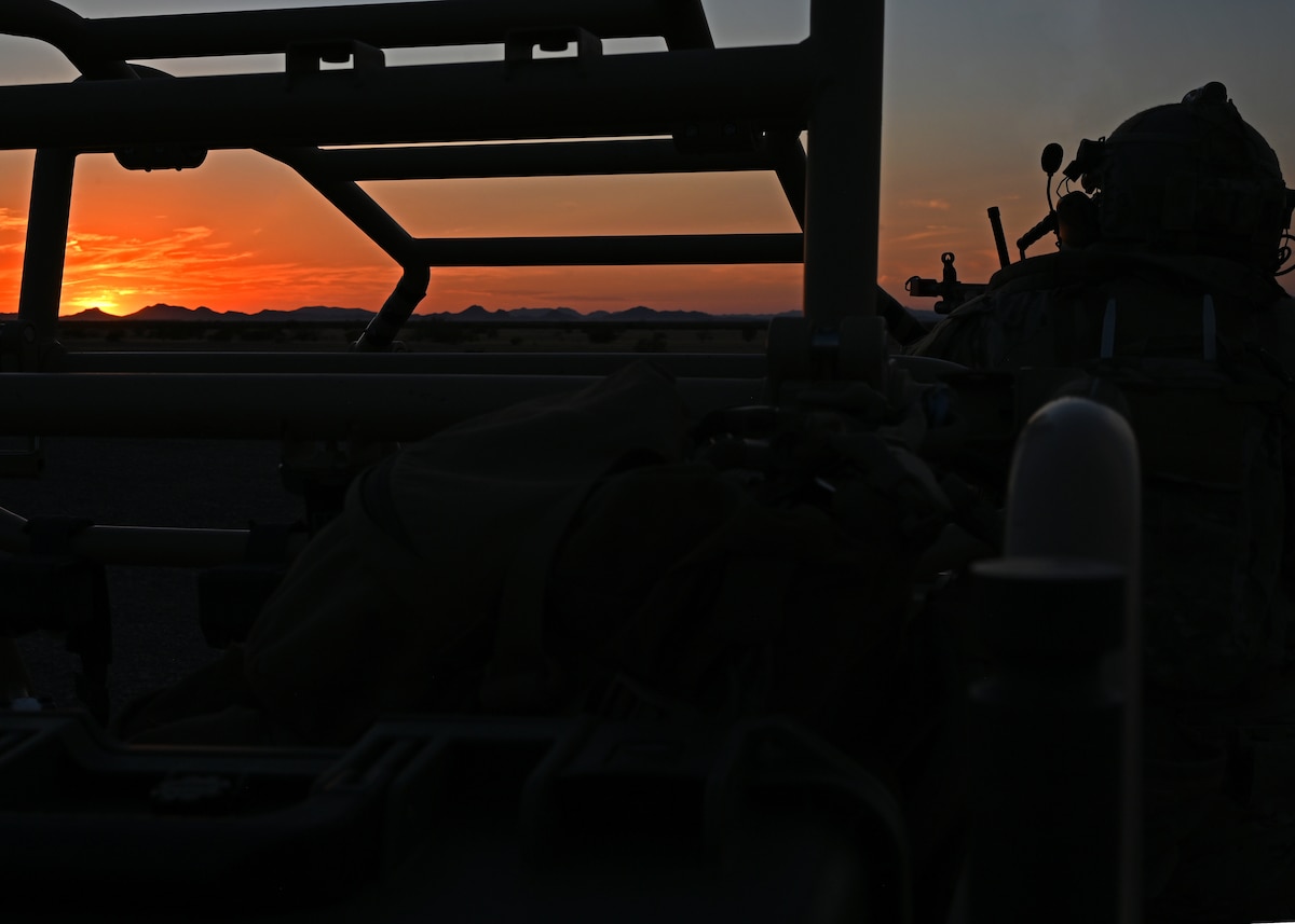 U.S. Air Force Senior Airman Jassiel Gallo Bravo, 27th Special Operations Support Squadron deployed aircraft ground response element team member, tests his equipment before a training scenario commences at the Barry M. Goldwater Range, Gila Bend, Ariz., July 18, 2024. The training scenario was hosted by the 48th Rescue Squadron to certify new members onto the Special Warfare Team-3. (U.S. Air Force photo by Staff Sgt. Abbey Rieves)