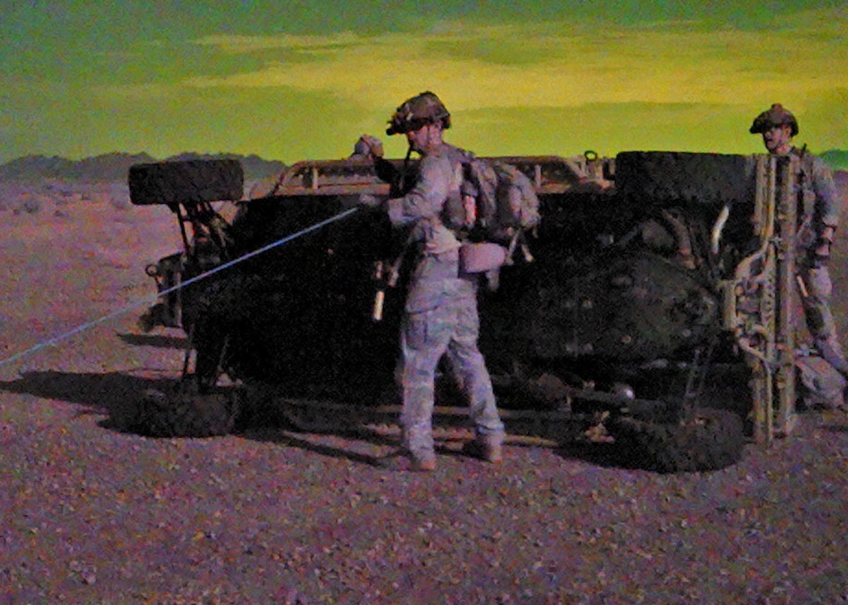 U.S. Air Force Special Warfare Team-3 members assigned to the 48th Rescue Squadron attach a winch to a flipped utility task vehicle in a rescue scenario at the Barry M. Goldwater Range, Gila Bend, Ariz., July 18, 2024. The UTVs were dropped in by air support for the SWT-3 to rescue and recover personnel in a simulated mass casualty scenario. (U.S. Air Force photo by Staff Sgt. Abbey Rieves)