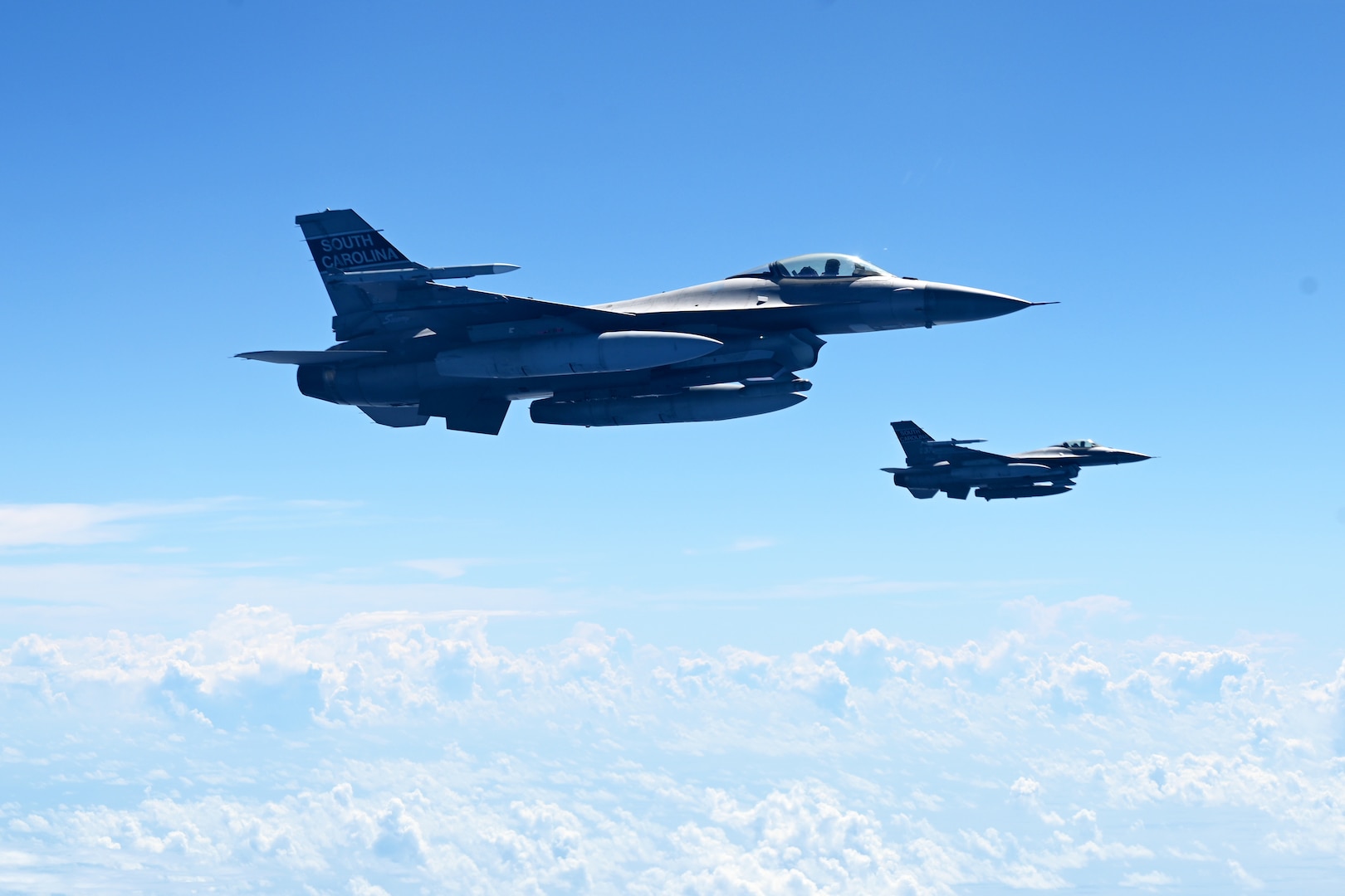 Two F-16 Fighting Falcon fighter jets assigned to the South Carolina Air National Guard’s 169th Fighting Wing soar above St. Croix, U.S. Virgin Islands, during exercise Caribbean Fox July 22, 2024. Caribbean Fox provides a dynamic training experience for the warfighter to maintain readiness to integrate, operate and dominate air superiority across the full spectrum of conflict.