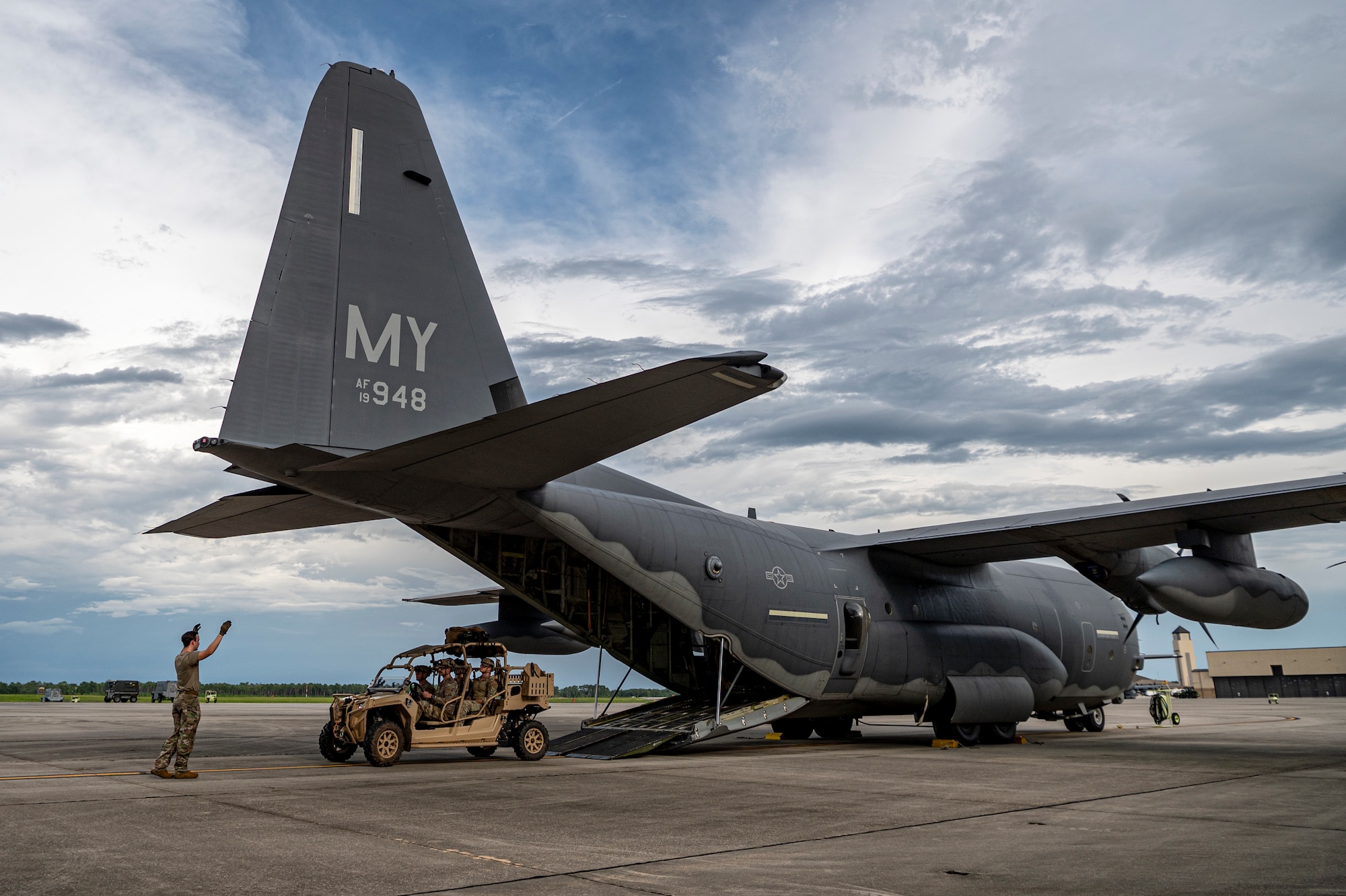 U.S. Air Force Airman 1st Class Eric Peltier, 71st Rescue Squadron loadmaster, assists in guiding Airmen assigned to 38th RQS into an HC-130J Combat King II at Moody Air Force Base, Georgia, July 24, 2024. 71st Airmen from different rescue squadrons work together to perform combat search and rescue operations in different theaters all over the globe. (U.S. Air Force photo by Senior Airman Leonid Soubbotine)