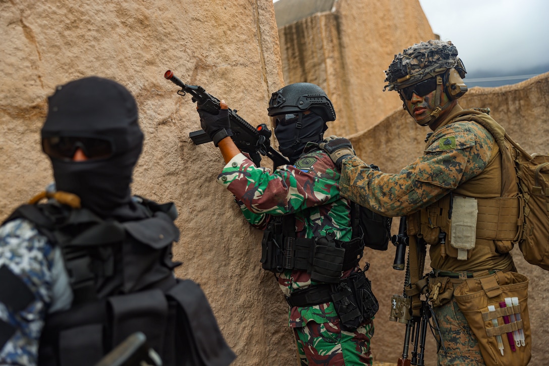 U.S. Marine Corps Sgt. Gerardo Casas, right, a team leader assigned to Charlie Company, Battalion Landing Team 1/5, 15th Marine Expeditionary Unit, positions an Indonesian marine to hold security during an air assault exercise, during Exercise Rim of the Pacific 2024 at Marine Corps Base Hawaii, July 12. Twenty-nine nations, 40 surface ships, three submarines, 14 national land forces, more than 150 aircraft and 25,000 personnel are participating in RIMPAC in and around the Hawaiian Islands, June 27 to Aug. 1. The world's largest international maritime exercise, RIMPAC provides a unique training opportunity while fostering and sustaining cooperative relationships among participants critical to ensuring the safety of sea lanes and security on the world's oceans. RIMPAC 2024 is the 29th exercise in the series that began in 1971. (U.S. Marine Corps photo by Cpl. Aidan Hekker)