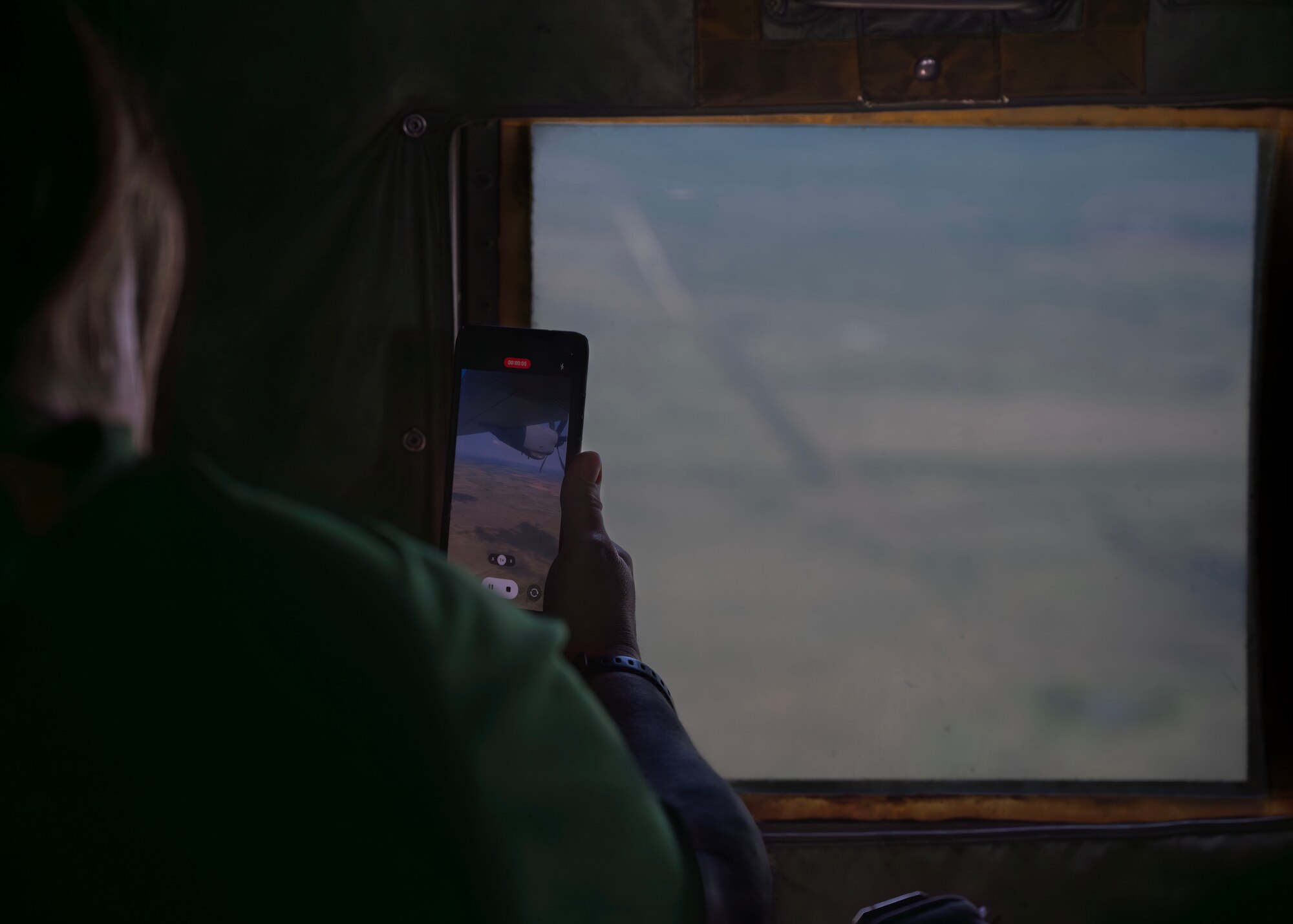 Goodfellow Air Force Base honorary commander records a video during an incentive flight at Dyess Air Force Base, Texas, July 24, 2024. The 317th Airlift Wing flew Goodfellow’s honorary commanders on a C-130J Super Hercules, giving them a taste of one of the operational Air Force missions the 17th Training Wing supports. (U.S. Air Force photo by Senior Airman Sarah Williams)
