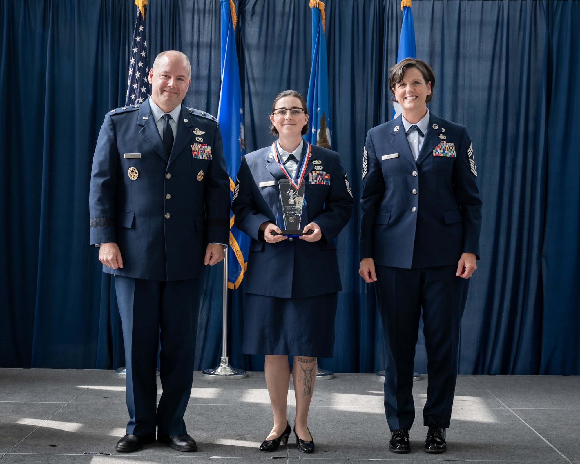 U.S. Air Force Master Sgt. Haley Rankin, a weapons director for the Western Air Defense Sector’s 225th Air Defense Squadron, Washington Air National Guard poses with Maj. Gen. Duke Pirak, left, acting director, Air National Guard and Chief Master Sgt. Lisa Perry, interim command chief, ANG, after being recognized as the Outstanding Non-Commissioned Officer of the Year during a ceremony at the Air National Guard Readiness Center, Joint Base Andrews, Maryland, July 26, 2024. The ceremony was part of Focus on the Force Week 2024—an annual, week-long event hosted by Air National Guard senior enlisted leadership designed to highlight professional development and honor the achievements of the enlisted corps’ top performing members. (U.S. Air National Guard photo by Master Sgt. Brandy Fowler)