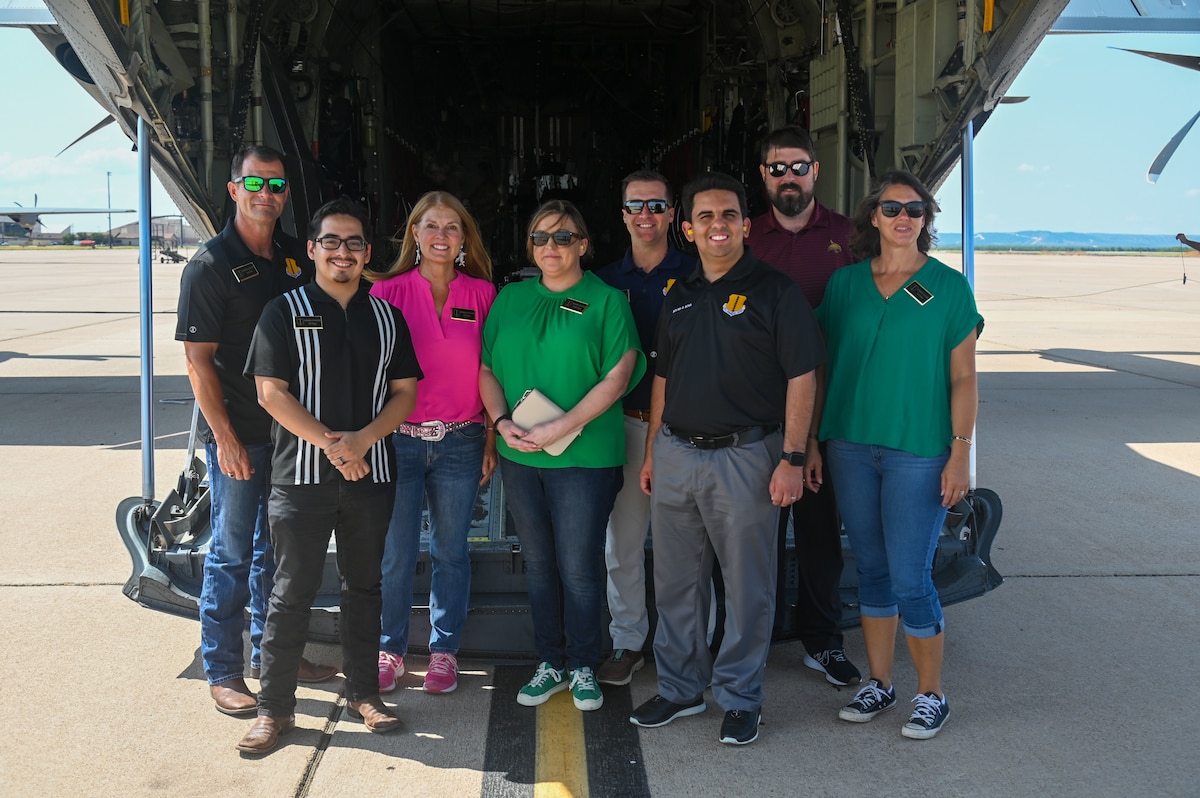 Honorary commanders from Goodfellow Air Force Base, stand behind a C-130J Super Hercules at Dyess Air Force Base, Texas, July 24, 2024. The 317th Airlift Wing flew San Angelo community leaders on a C-130J Super Hercules, giving them a taste of the operational Air Force mission. (U.S. Air Force photo by Airman 1st Class James Salellas)