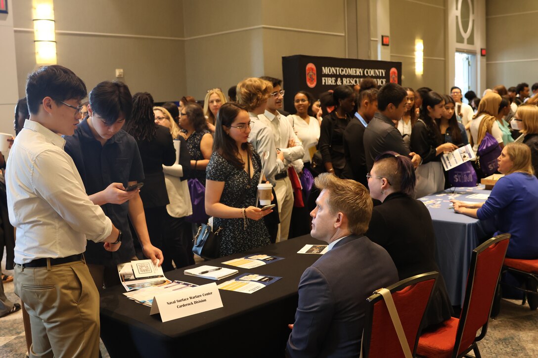 Montgomery County Public Schools’ Summer RISE Program interns chat with the Carderock’s table at the program career fair session at the Bethesda North Marriott Hotel and Conference Center in Rockville, Md., July 25, 2024.