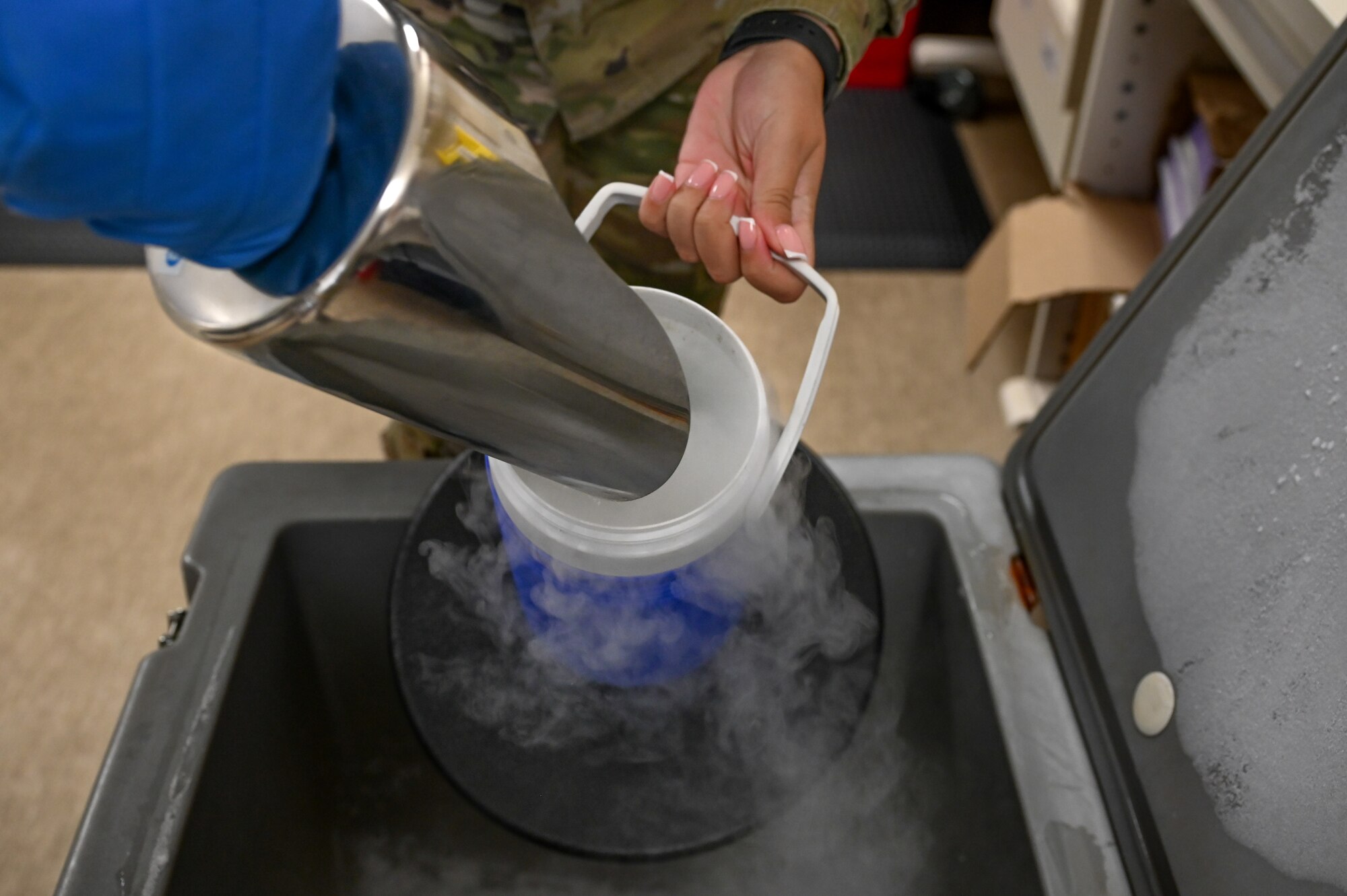 Airman transfers dry ice to container.