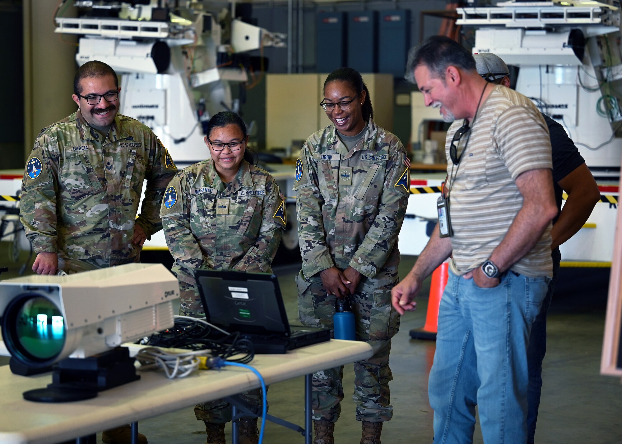 Servicemembers looking at a computer.