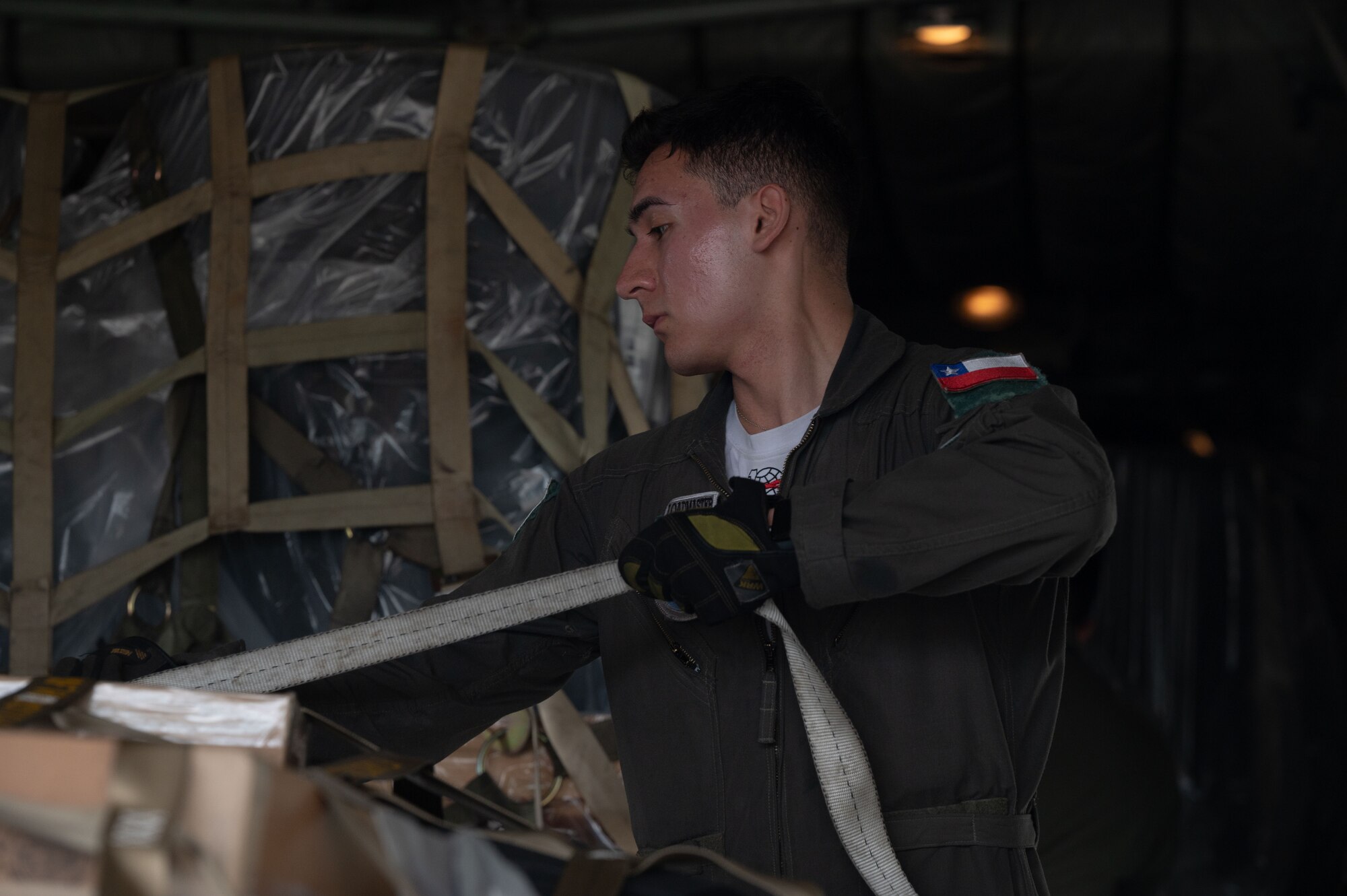 A member of the Chilean Air Force secures a strap on cargo aboard a Chilean Air Force  C-130 Hercules at Dover Air Force Base, Delaware, July 23, 2024. The visit was part of a multi-day Foreign Military Sales mission between the United States and Chile. Chile is one of the United States’ strongest partners in Latin America and a leader in promoting respect for the rule of law, economic stability, education, environmental protection, human rights, and sustainable development. (U.S. Air Force photo by Senior Airman Dieondiere Jefferies)