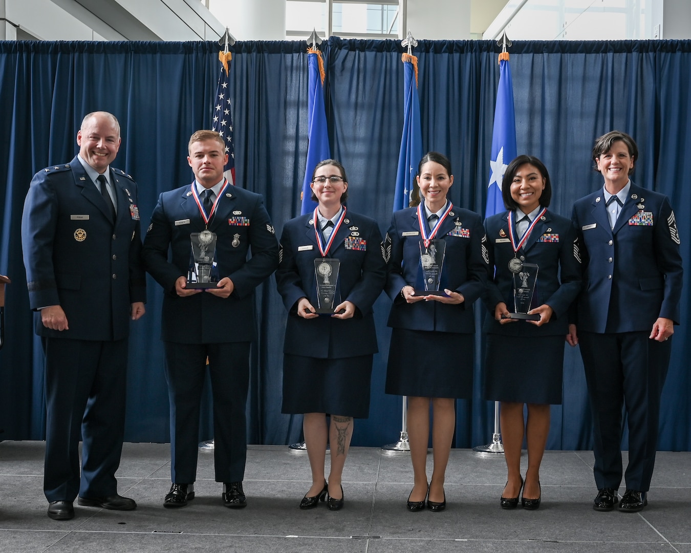 From left: U.S. Air Force Gen. Duke Pirak, acting director, Air National Guard; Senior Airman Gavin Woken,  121st Air Refueling Wing, Ohio National Guard; Master Sgt. Haley Rankin of the Western Air Defense Sector, Washington Air National Guard; Senior Master Sgt. Alejandra Rosales,  195th Wing, California Air National Guard; Master Sgt. Diana Nogiec, 110th Wing, Michigan National Guard; and Chief Master Sgt. Lisa Perry, interim command chief, Air National Guard pose for a group photo during the culmination of the Outstanding Airmen of the Year awards ceremony at the Air National Guard Readiness Center, Joint Base Andrews, Maryland, July 26, 2024.