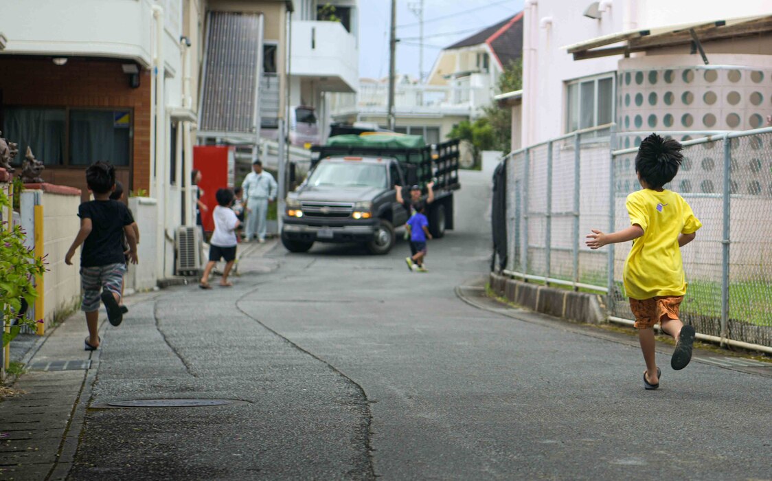 Children race to meet a vehicle carrying gifts and donations provided by U.S. military and families during a Christmas in July event at a child support facility outside Kadena Air Base, Japan, July 23, 2024.