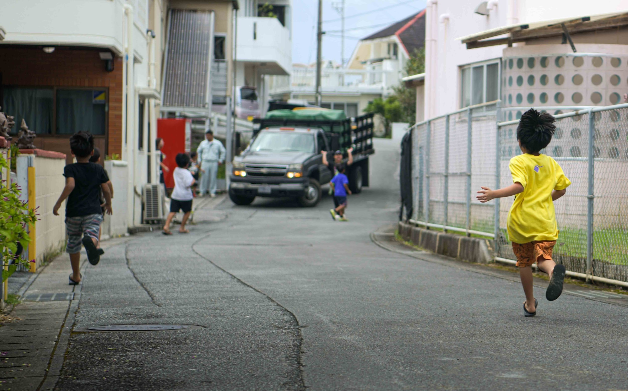 Children race to meet a vehicle carrying gifts and donations provided by U.S. military and families during a Christmas in July event at a child support facility outside Kadena Air Base, Japan, July 23, 2024.