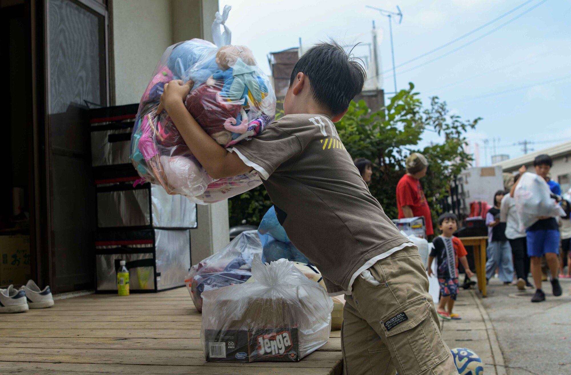A child lowers a bag of donated toys and clothing during a Christmas in July event at a child support facility outside Kadena Air Base, Japan, July 23, 2024.