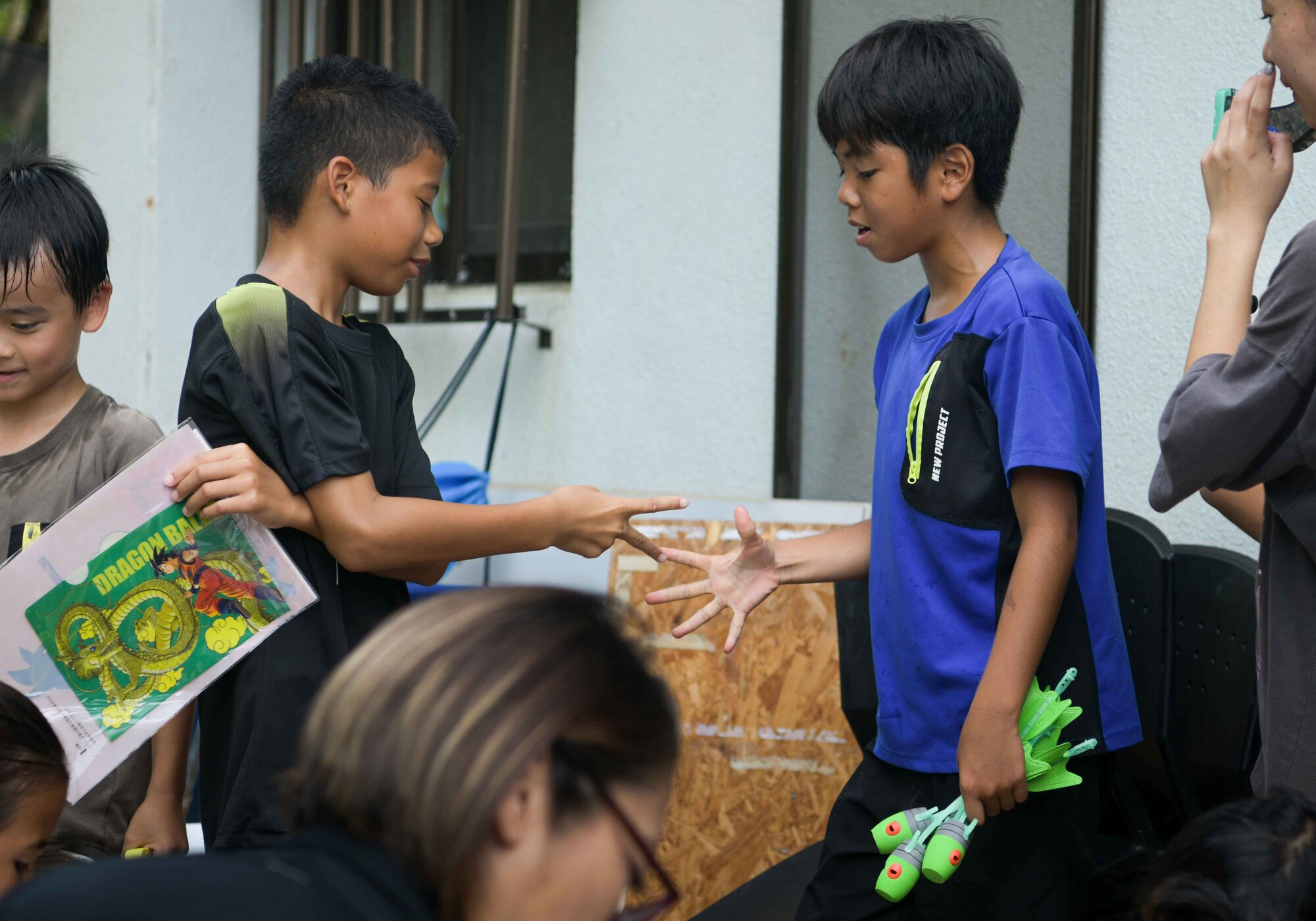 Two boys play rock-paper-scissors over a donated toy during a Christmas in July event at a child support facility outside Kadena Air Base, Japan, July 23, 2024