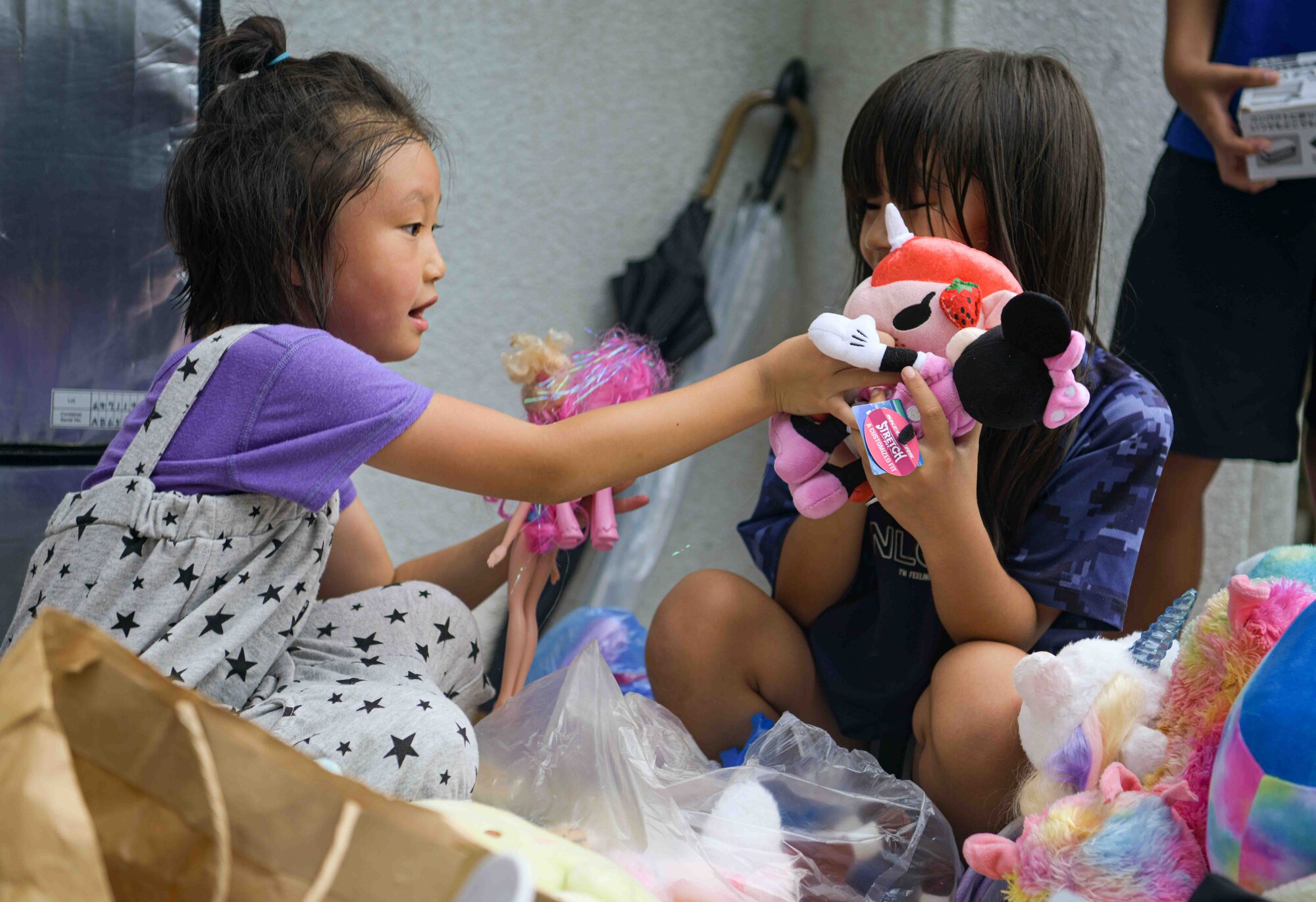 Two girls play with donated toys during a Christmas in July event at a child support facility outside Kadena Air Base, Japan, July 23, 2024.