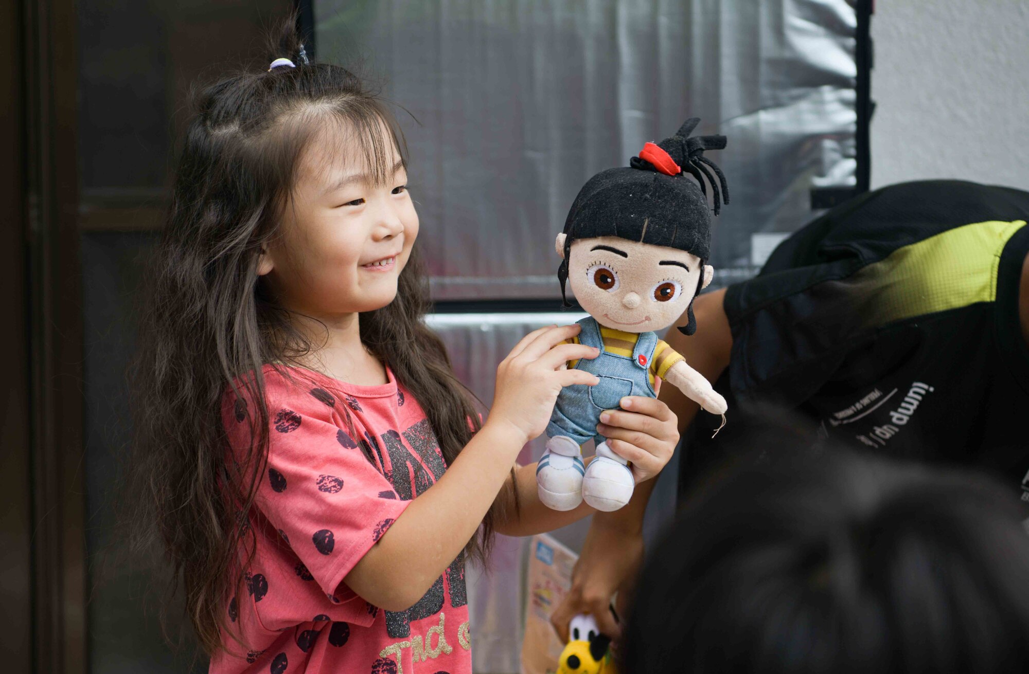 A young girl plays with a donated doll during a Christmas in July event at a child support facility outside Kadena Air Base, Japan, July 23, 2024.