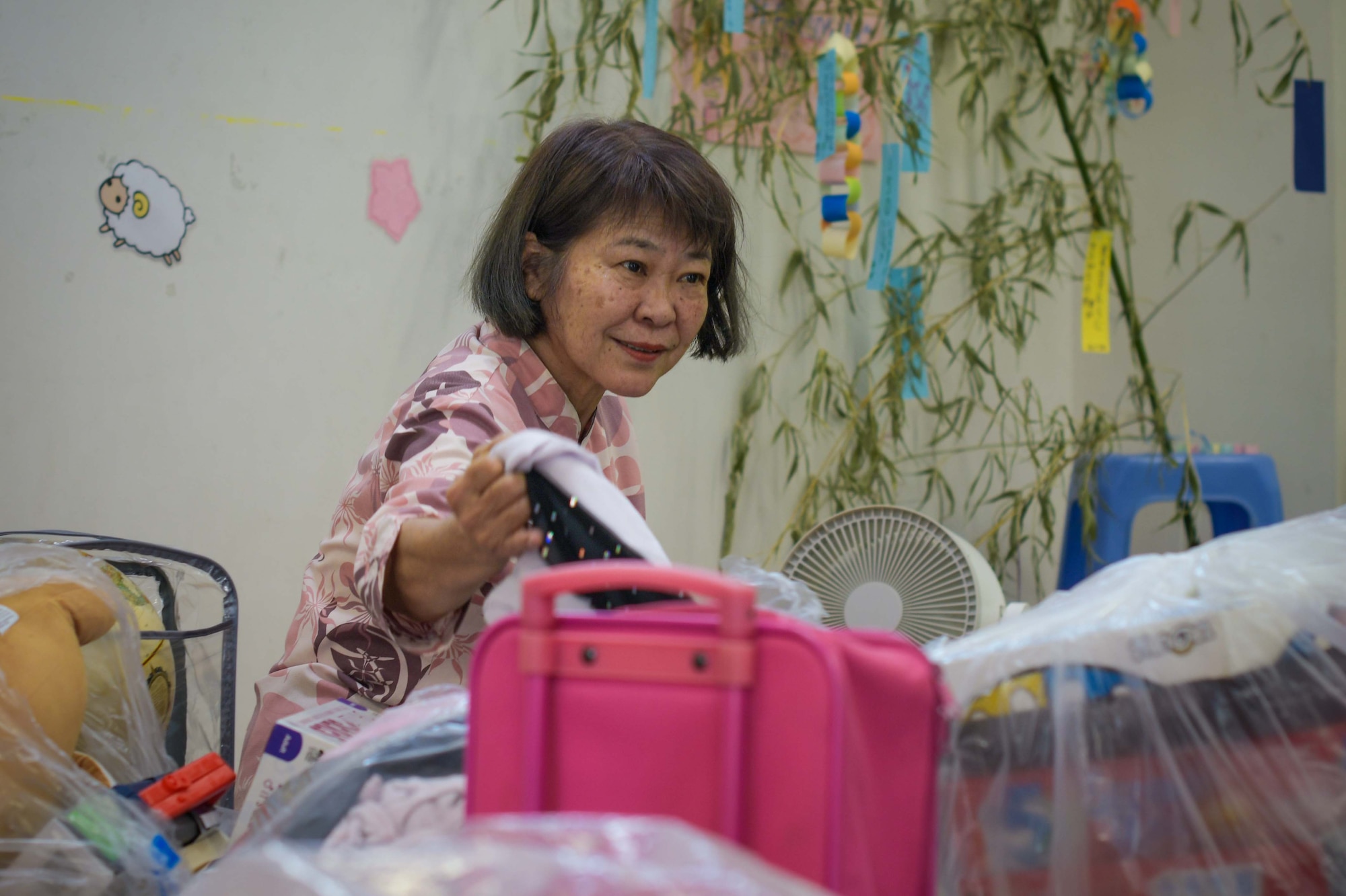A children’s support facility staff member sorts through donations made by local military members and family during a Christmas in July event at a child support facility outside Kadena Air Base, Japan, July 23, 2024.
