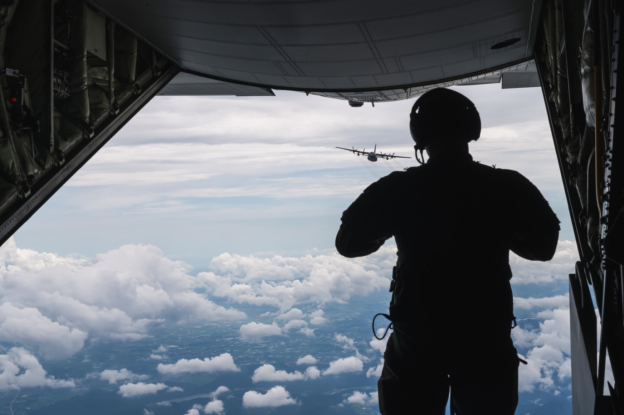 An Airman assigned to the 320th Special Tactics Squadron, observes a Republic of Korea Air Force MC-130K, as it trails a U.S. Air Force MC-130J Commando II over Kunsan Air Base, Republic of Korea.