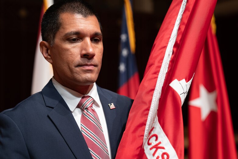 Mr. Howard Gonzales, U.S. Army Corps of Engineers Jacksonville Deputy District for Programs and Project Management, holds the organizational Colors, before passing them to Col. James Booth, outgoing Jacksonville District commander, during a change of command ceremony at the Jacksonville Center for the Performing Arts Jacoby Symphony Hall in Jacksonville, Fl., July 26, 2025.  (U.S. Army Photo by Brigida I. Sanchez)