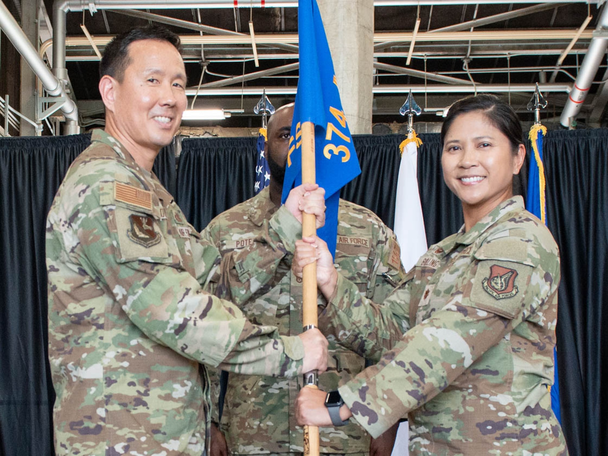 U.S. Air Force Col. Burt Okamoto, 374th Mission Support Group commander, left, presents the guidon to Maj. Hasmin Bolling, 374th Force Support Squadron incoming commander.