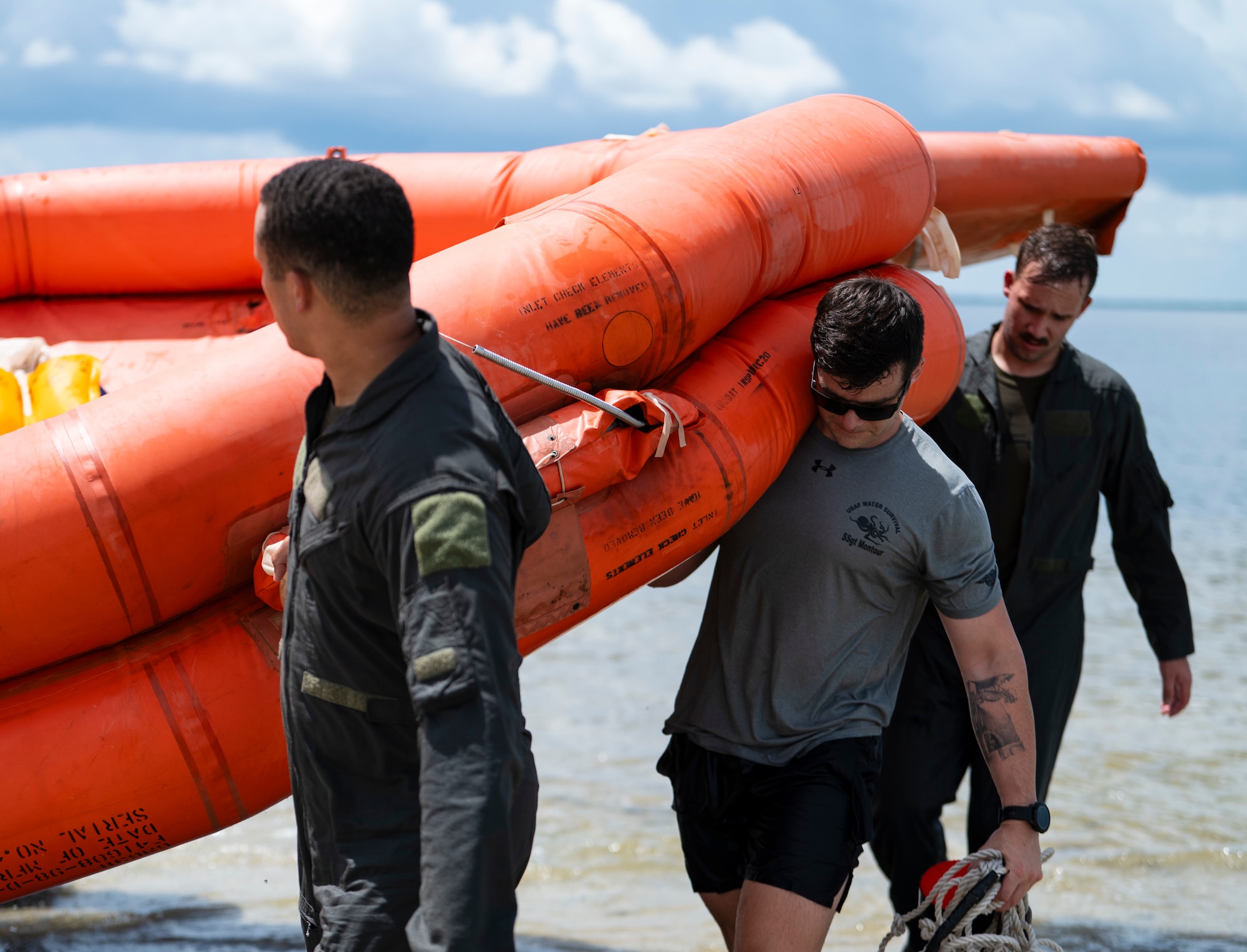 U.S. Air Force Airmen drag a life raft on shore during a water survival training exercise at MacDill Air Force Base, Florida, June 28, 2024. The training exercise was part of the Air Force’s Survival, Evasion, Resistance and Escape curriculum designed to prepare Airmen for escaping a downed aircraft in open water. (U.S. Air Force photo by Airman 1st Class Alicia Campbell)