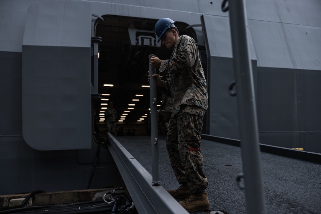U.S. Marine Corps Cpl. Darren Camp, a logistics specialist with Combat Logistics Battalion 22, Combat Logistics Regiment 2, 2nd Marine Logistics Group, removes a post during Defense Support of Civil Authorities mission rehearsals at Naval Base Norfolk, Virginia, July 22, 2024. Marines and Sailors with the II Marine Expeditionary Force (II MEF) Maritime DSCA Task Force conducted a full mission rehearsal in order to practice deploying as a team in support of civil authorities. This rehearsal was designed by II MEF and United States Fleet Forces Command to integrate and increase amphibious capabilities on the East Coast for potential humanitarian relief and disaster assistance mission during this hurricane season. (U.S. Marine Corps photo by Cpl. Meshaq Hylton)