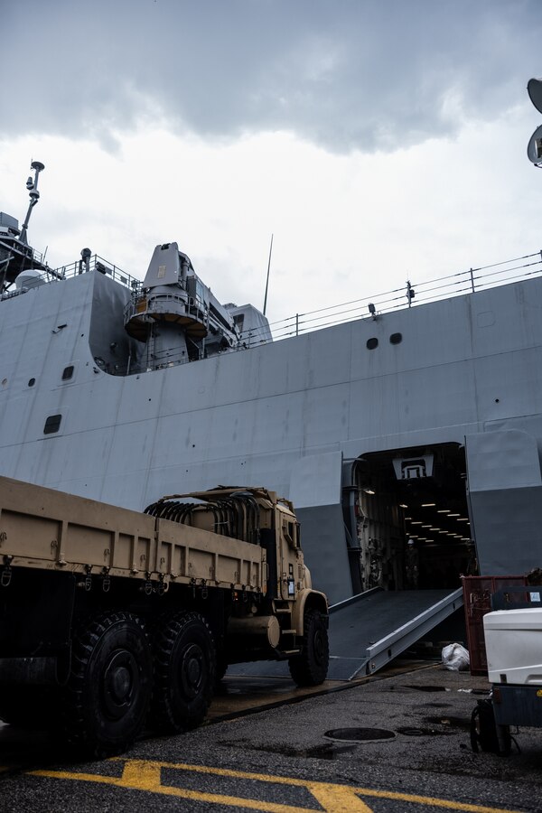 A U.S. Marine with Combat Logistics Battalion 22, Combat Logistics Regiment 2, 2nd Marine Logistics Group, drives a medium tactical vehicle replacement onto the USS Fort Lauderdale (LPD-28) during Defense Support of Civil Authorities mission rehearsals at Naval Base Norfolk, Virginia, July 22, 2024. Marines and Sailors with the II Marine Expeditionary Force (II MEF) Maritime DSCA Task Force conducted a full mission rehearsal in order to practice deploying as a team in support of civil authorities. This rehearsal was designed by II MEF and United States Fleet Forces Command to integrate and increase amphibious capabilities on the East Coast for potential humanitarian relief and disaster assistance mission during this hurricane season. (U.S. Marine Corps photo by Cpl. Meshaq Hylton)
