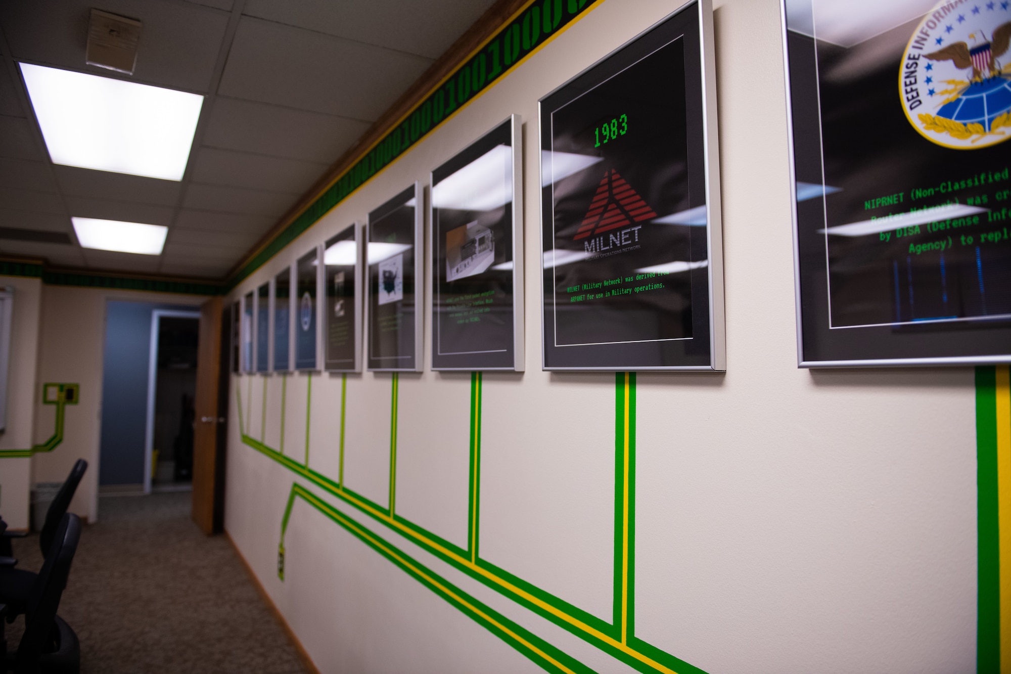Placards of historical facts about the 319th Communications Squadron hang on a designed wall.