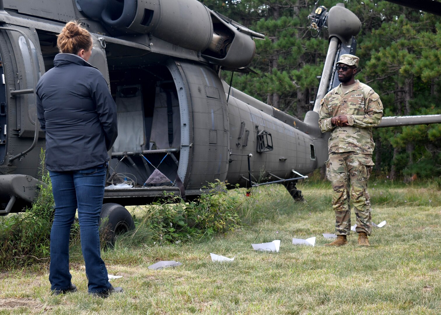 Soldier in recovery from Fort Drum SRU speaks to Boulder Crest Foundation facilitator in front of training helicopter.