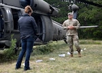 Soldier in recovery from Fort Drum SRU speaks to Boulder Crest Foundation facilitator next to training helicopter.