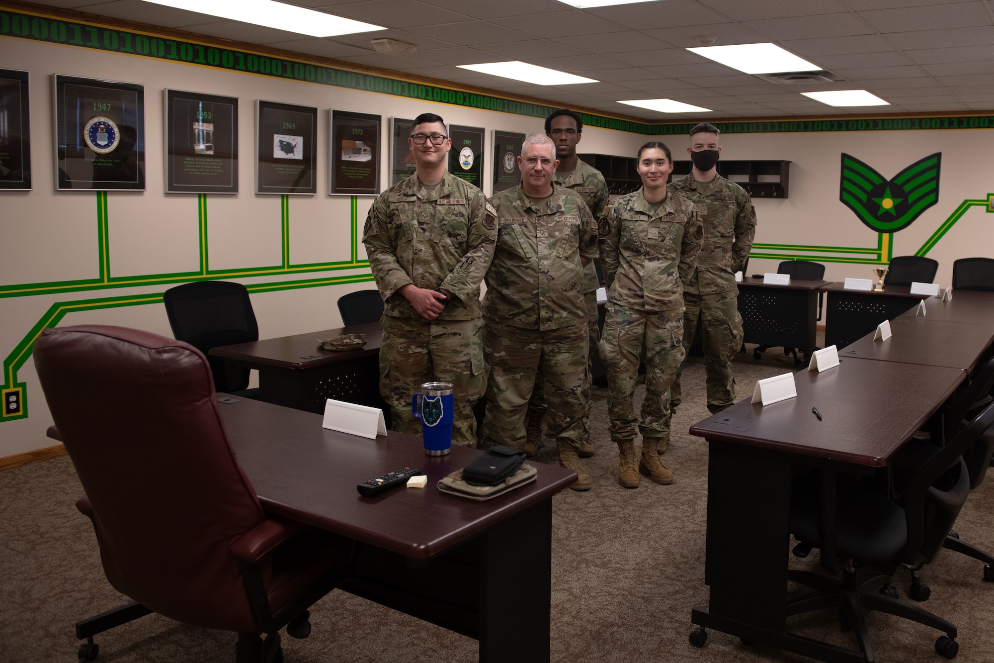 Five airmen stand and smile for the camera.