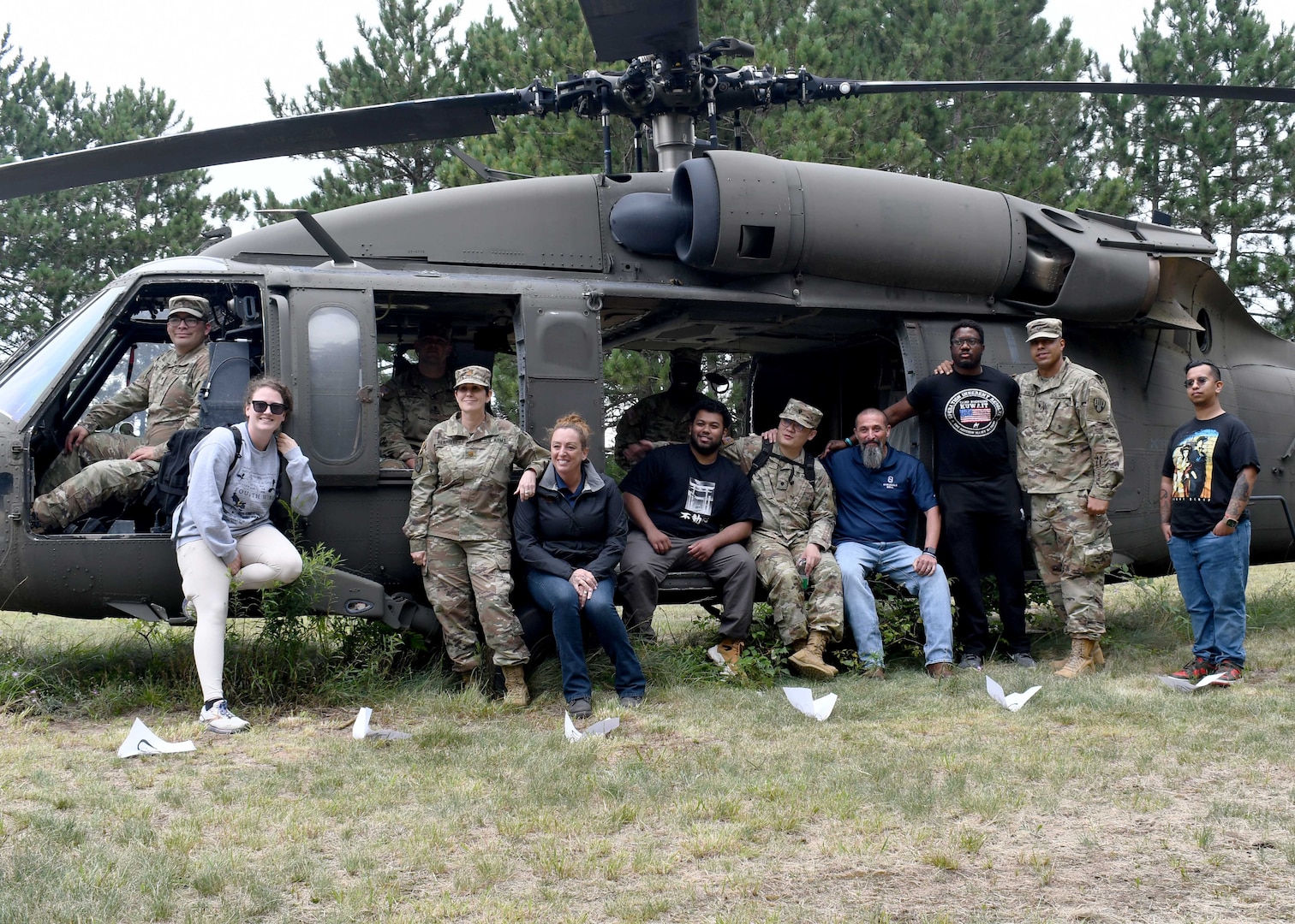 Soldiers in recovery from Fort Drum SRU stand for a photo with facilitators from the Boulder Crest Foundation in front of training helicopter.