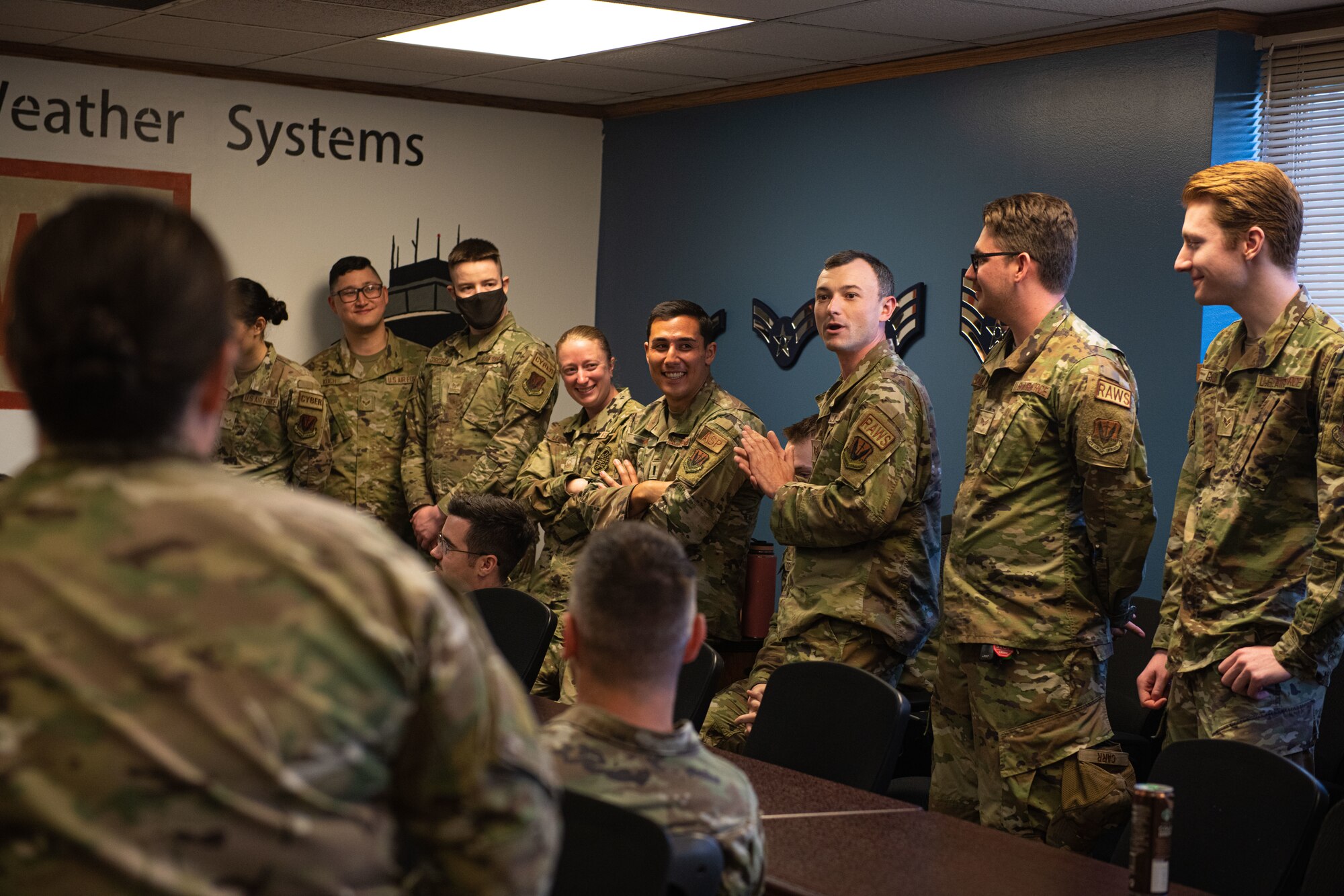 A crowd of airmen watch a sergeant speak.