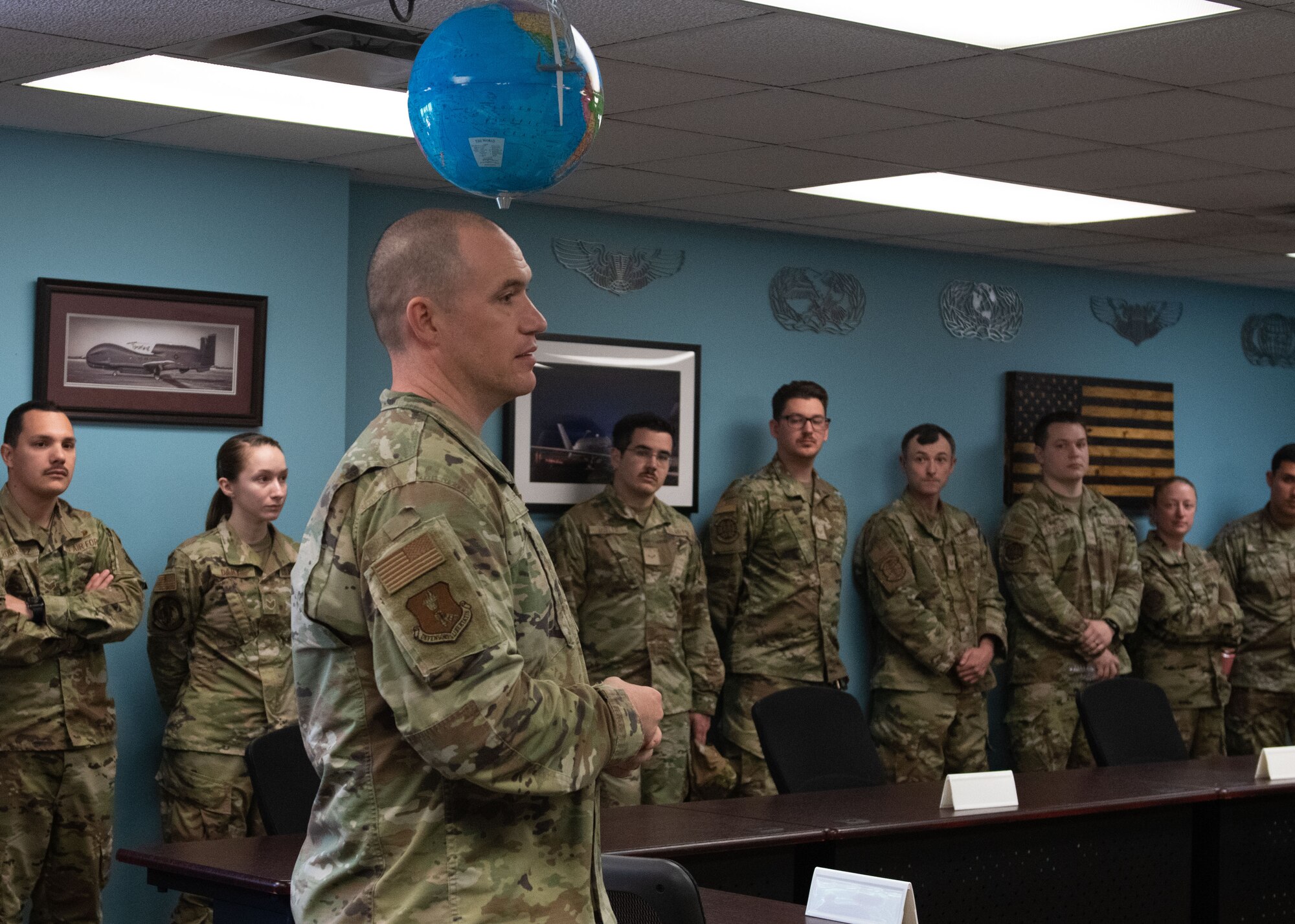 Man in uniform speaks to airmen.