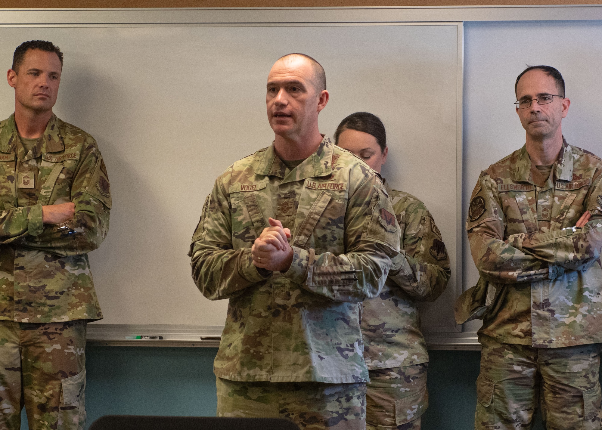 Man in uniform speaks to airmen.