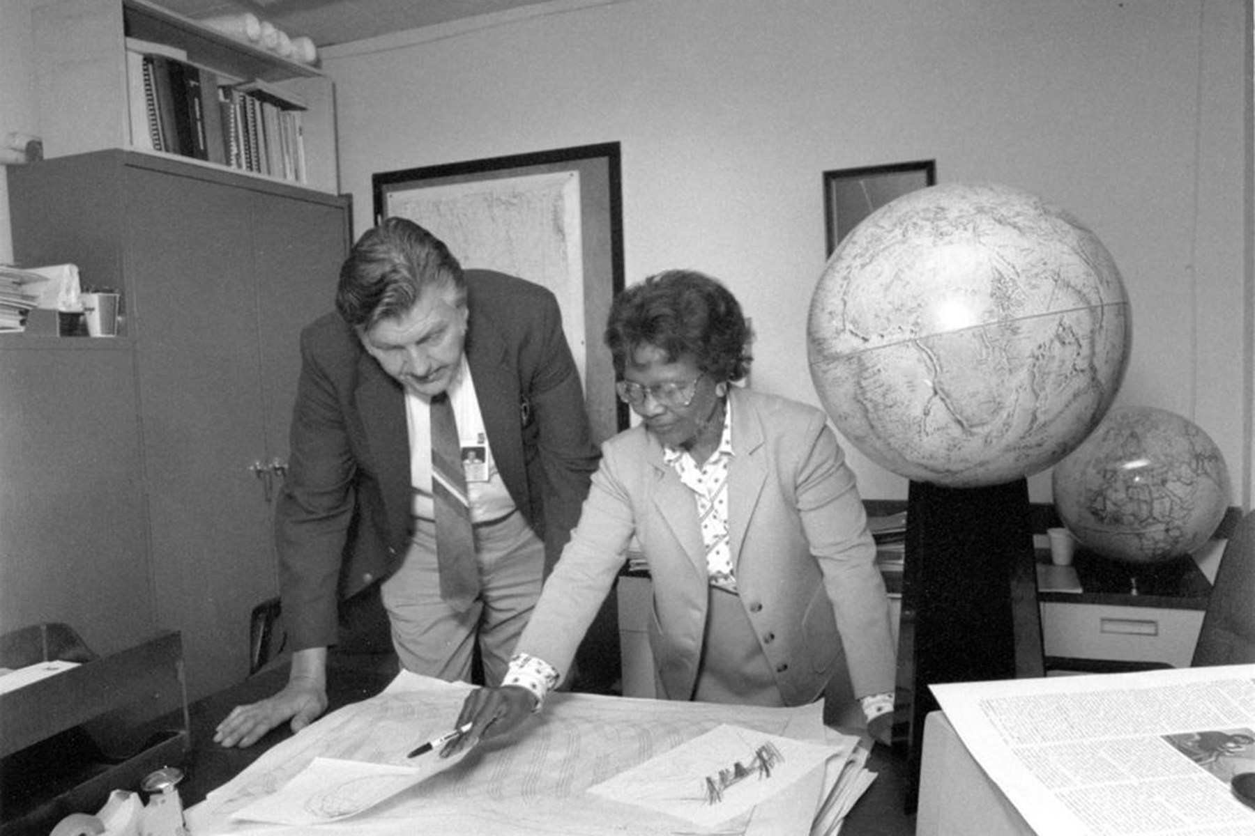 Dr. Gladys West and Sam Smith look over data from the Global Positioning System