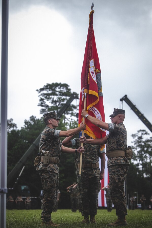 U.S. Marine Corps Lt. Col. Chad T. Phillips, left, incoming commanding officer, Headquarters and Service Battalion, 2nd Marine Logistics Group, receives Battalion colors from Lt. Col. Brian T. Everett, outgoing commanding officer, Headquarters and Service Battalion, 2nd MLG, during a change of command ceremony on Camp Lejeune, North Carolina, July 26, 2024. During the ceremony, Lt. Col. Everett relinquished command of Headquarters and Service Battalion to Lt. Col. Phillips. (U.S. Marine Corps photo by Cpl. Meshaq Hylton)
