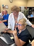 (L) Dr. Liza Pilch, Milwaukee MEPS chief medical officer, works alongside Helen Smith, Milwaukee MEPS medical technician, to review applicant prescreens. Milwaukee MEPS is one of 30 MEPS in phase III of a change to the workflow of medical prescreens for military applicants.