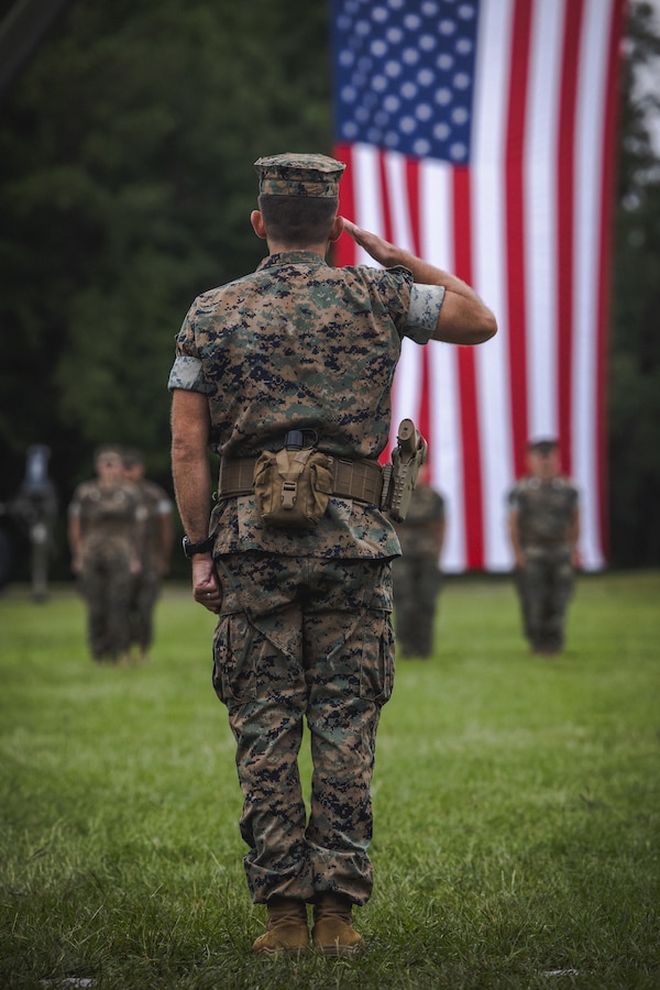 U.S. Marine Corps Lt. Col. Chad T. Phillips, incoming commanding officer, Headquarters and Service Battalion, 2nd Marine Logistics Group, salutes his new battalion during a change of command ceremony on Camp Lejeune, North Carolina, July 26, 2024. During the ceremony, U.S. Marine Corps Lt. Col. Brian T. Everett relinquished command of Headquarters and Service Battalion to Lt. Col. Phillips. (U.S. Marine Corps photo by Cpl. Meshaq Hylton)