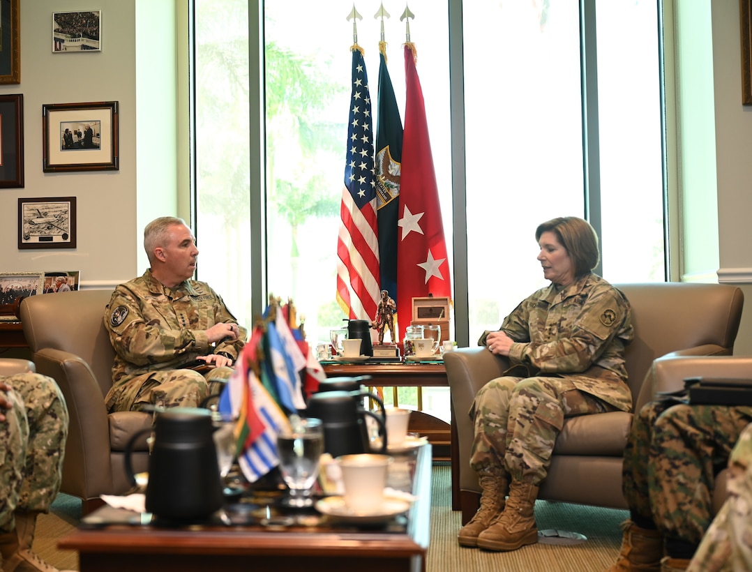 Military officers sit around a table.