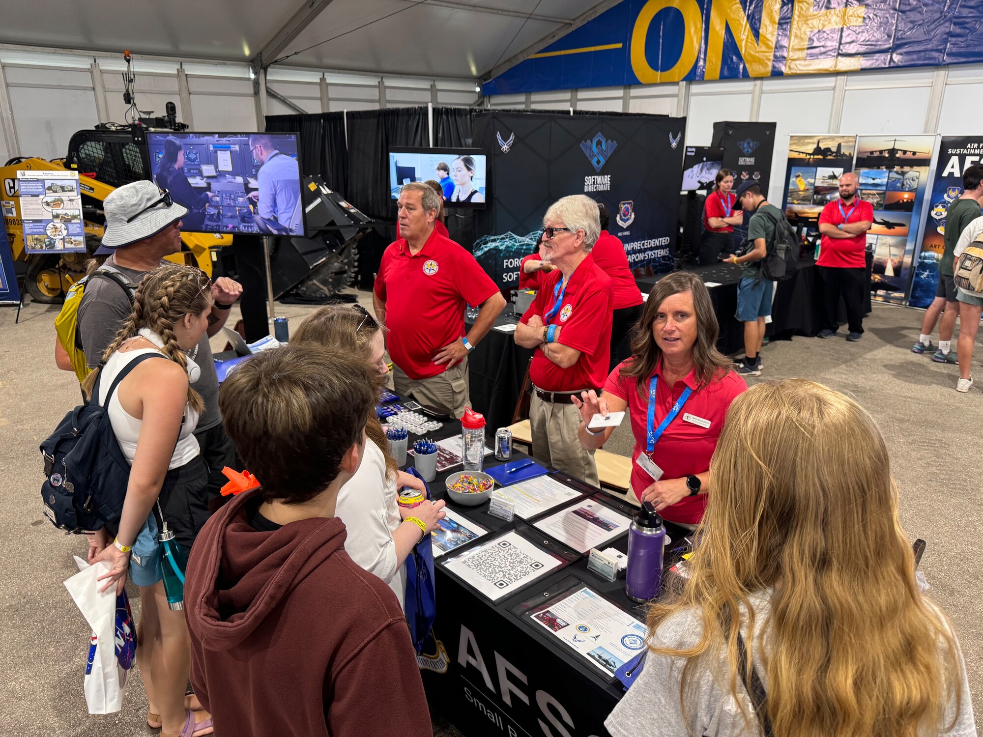 From left to right, Air Force Sustainment Center Logistics Directorate Representative Barry Collert, along with AFSC Small Business Directorate representatives Randy Miller, and Beth Shackelford greet visitors and explain the mission of AFSC and its support of the overall mission of Air Force Materiel Command during the opening day of the Experimental Aircraft Association’s AirVenture Oshkosh 2024 airshow in Oshkosh, Wi., July 22.